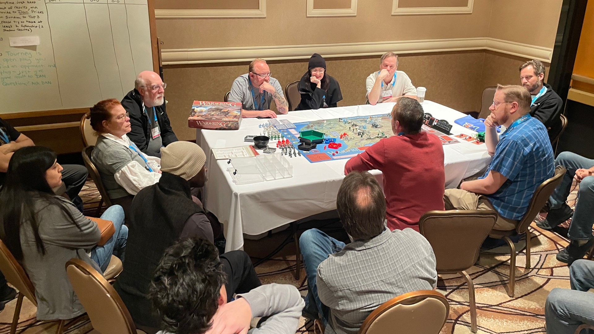 group of people playing a board game while others watch
